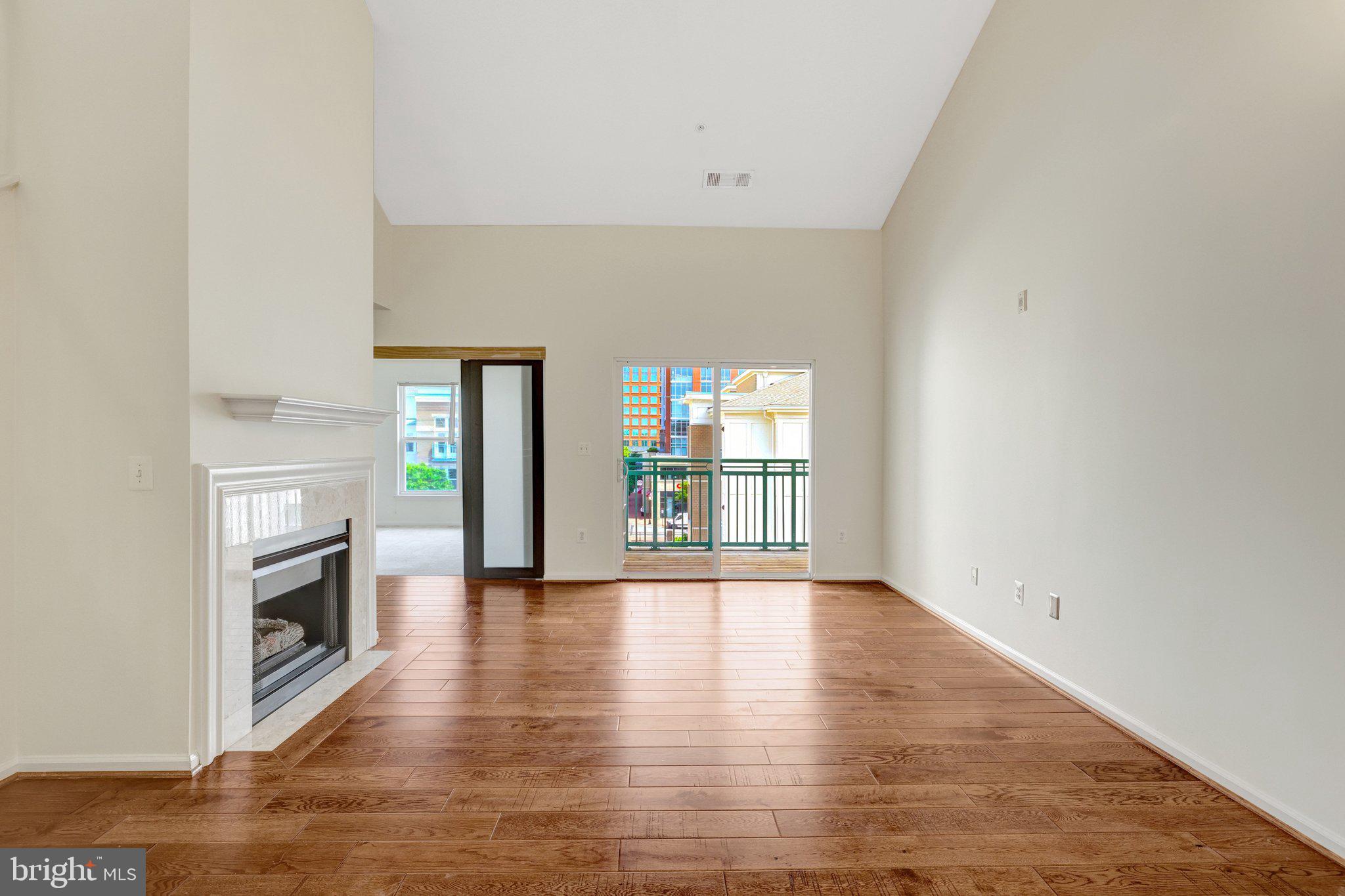 12001 Market Street, Unit 434 Reston, VA 20190 - Photo 16 of 43 a view of an empty room with a window and wooden floor