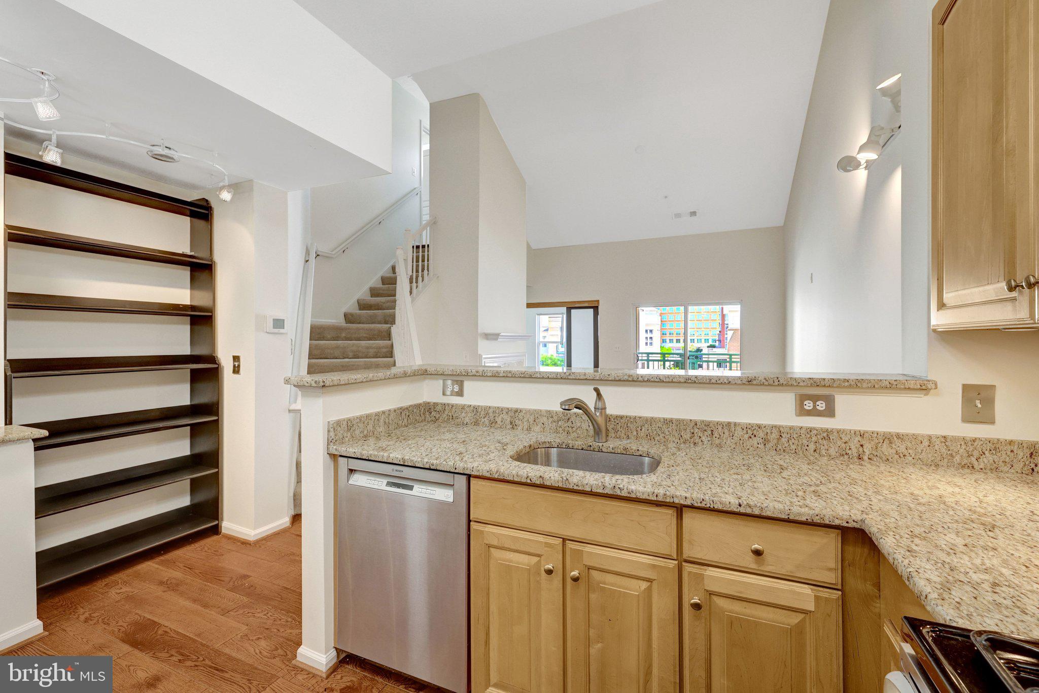 12001 Market Street, Unit 434 Reston, VA 20190 - Photo 17 of 43 a kitchen with granite countertop a sink and a window