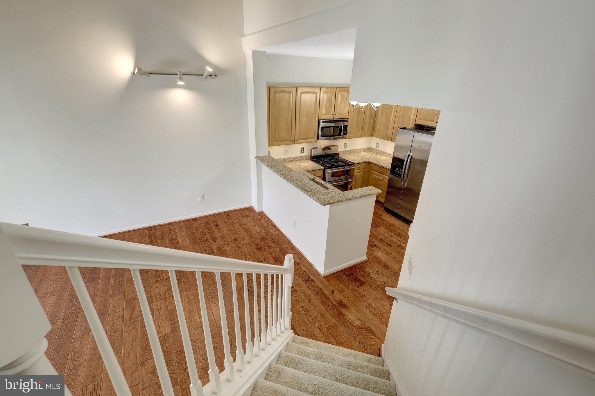 12001 Market Street, Unit 434 Reston, VA 20190 - Photo 26 of 43 a storage room with wooden floor and white walls