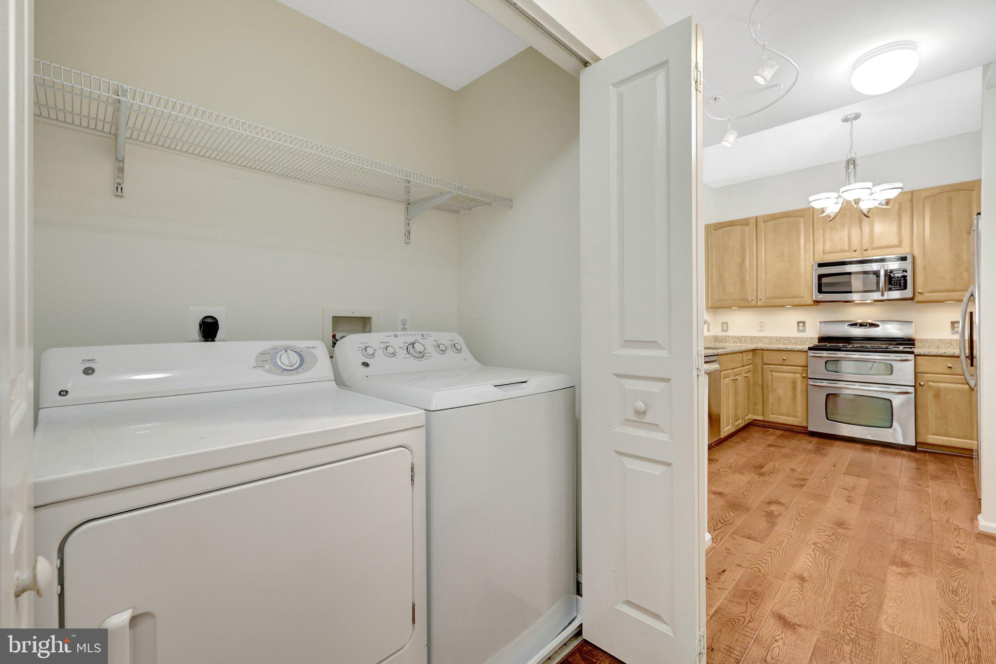 12001 Market Street, Unit 434 Reston, VA 20190 - Photo 31 of 43 a view of washer and dryer with kitchen in the background