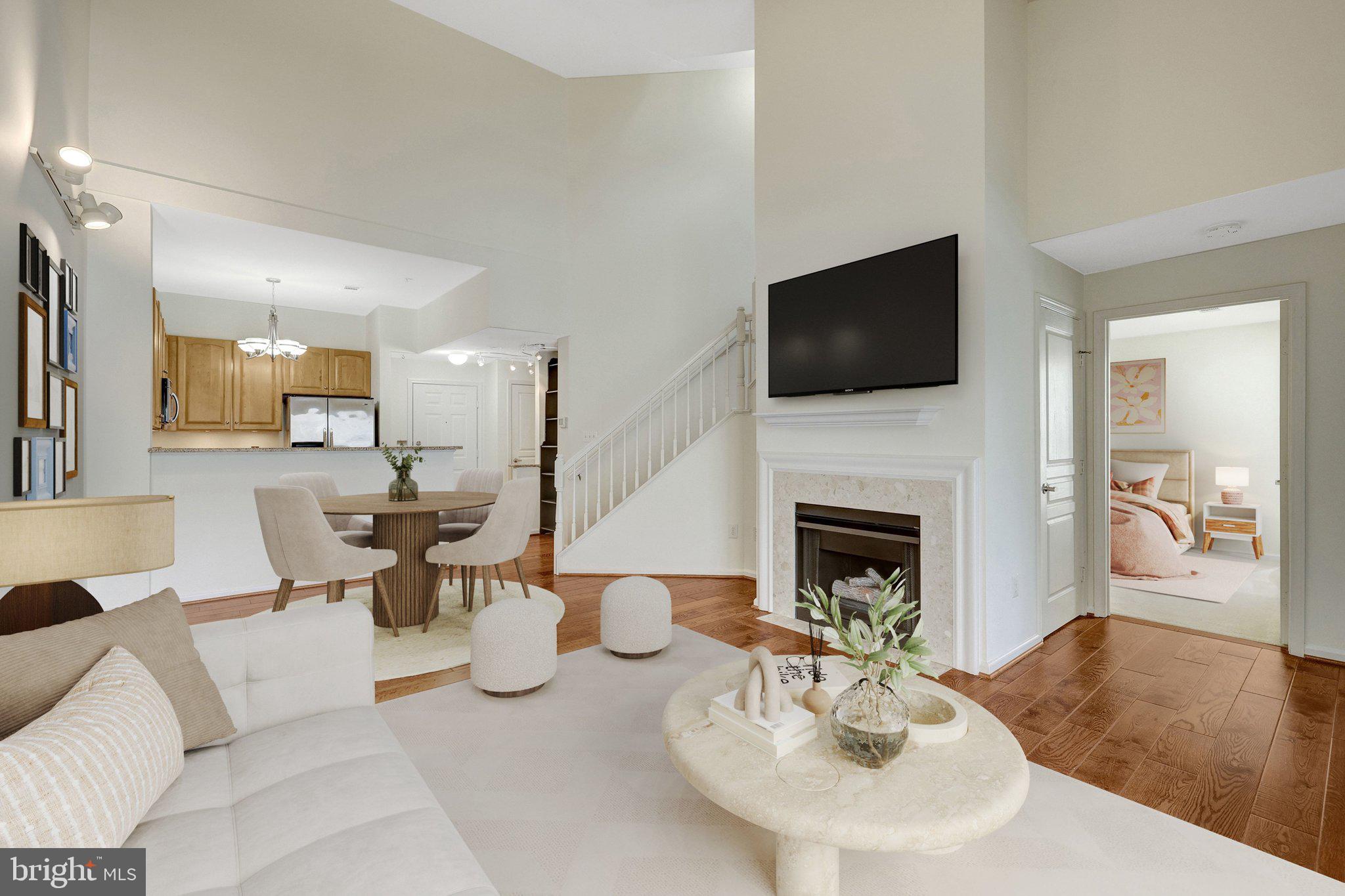12001 Market Street, Unit 434 Reston, VA 20190 - Photo 4 of 43 a living room with furniture a fireplace and a flat screen tv