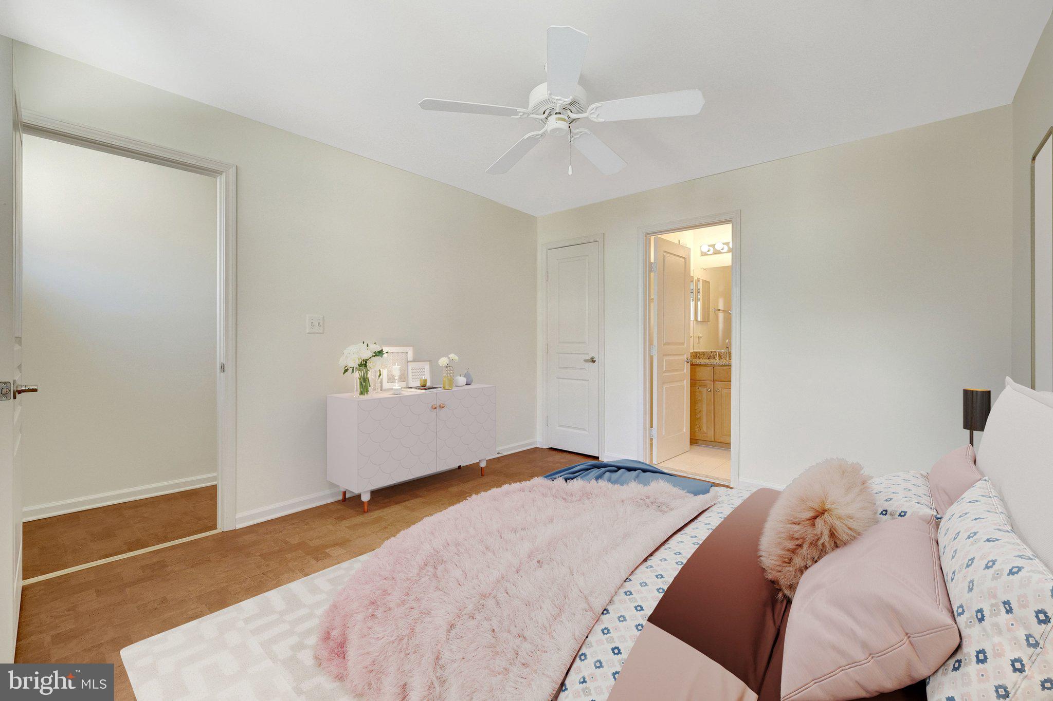 12001 Market Street, Unit 434 Reston, VA 20190 - Photo 7 of 43 a bedroom with a large bed and a chandelier fan