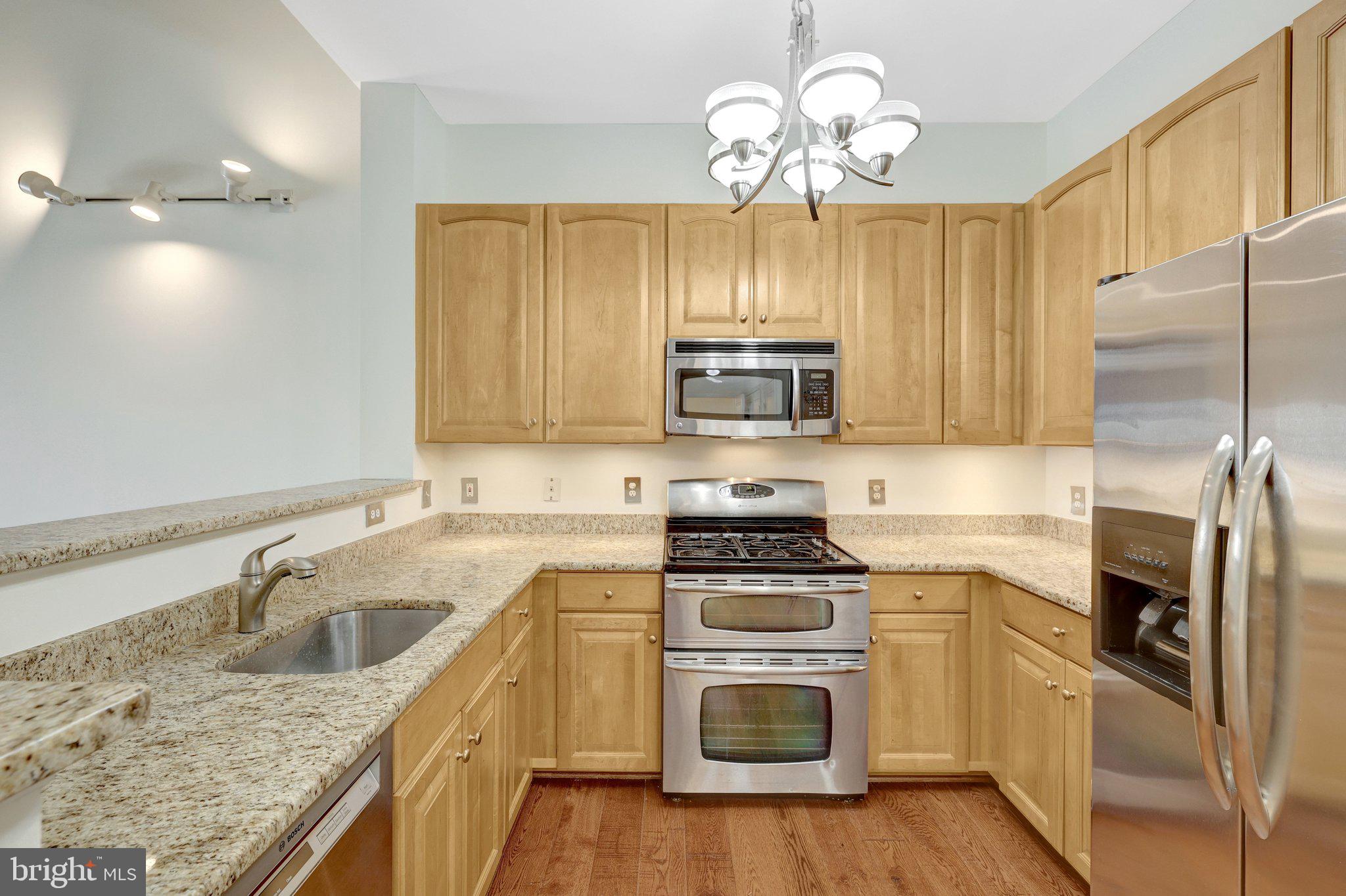 12001 Market Street, Unit 434 Reston, VA 20190 - Photo 9 of 43 a kitchen with a sink stove and microwave