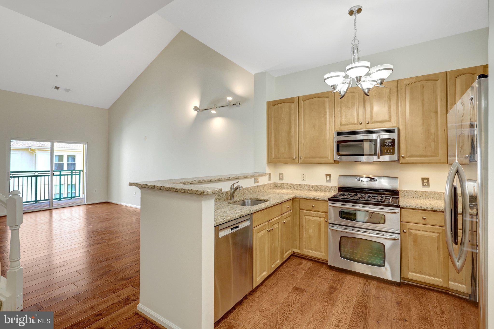 12001 Market Street, Unit 434 Reston, VA 20190 - Photo 10 of 43 a kitchen with a stove a sink and a refrigerator