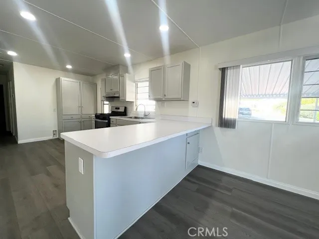 a kitchen with a sink a stove a refrigerator and white cabinets