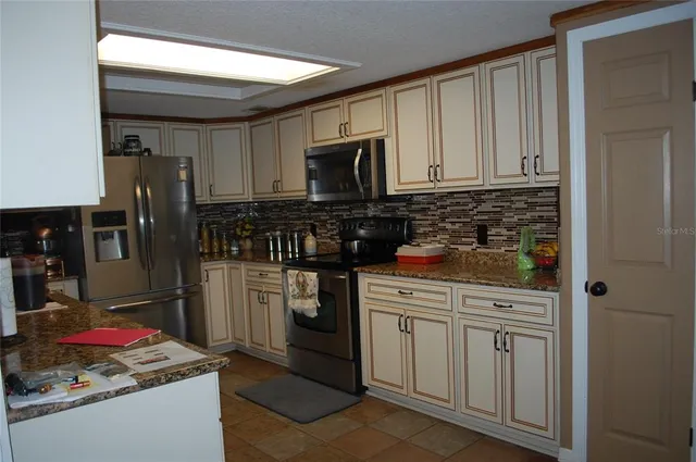 a kitchen with stainless steel appliances granite countertop a stove a refrigerator and a microwave