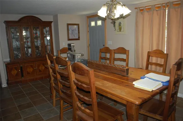 a view of a dining room with furniture and chandelier