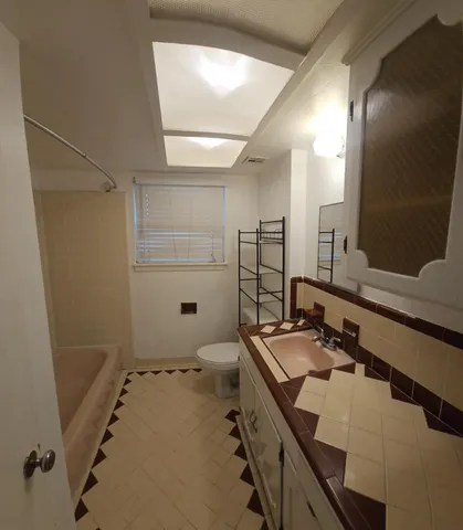 a view of an empty room with a chandelier fan