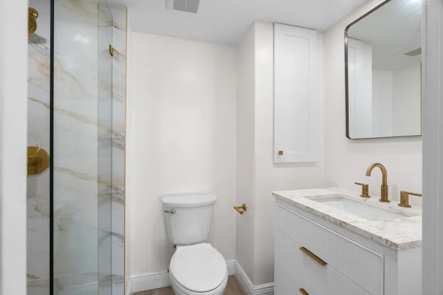 a bathroom with a toilet a sink and a mirror