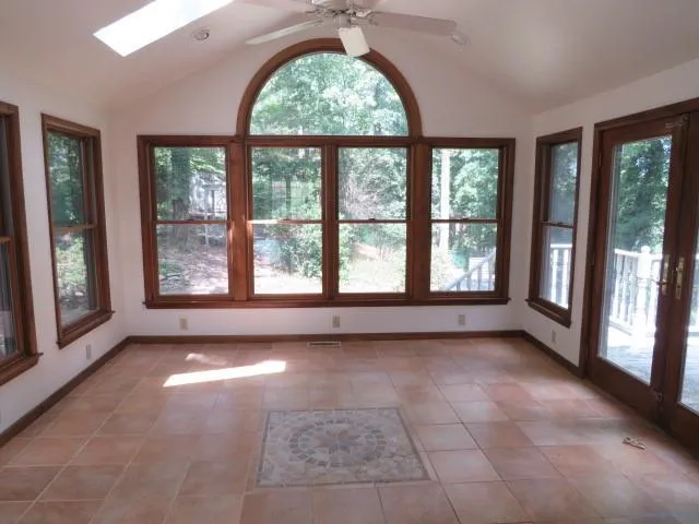 a view of a big room with windows and front door
