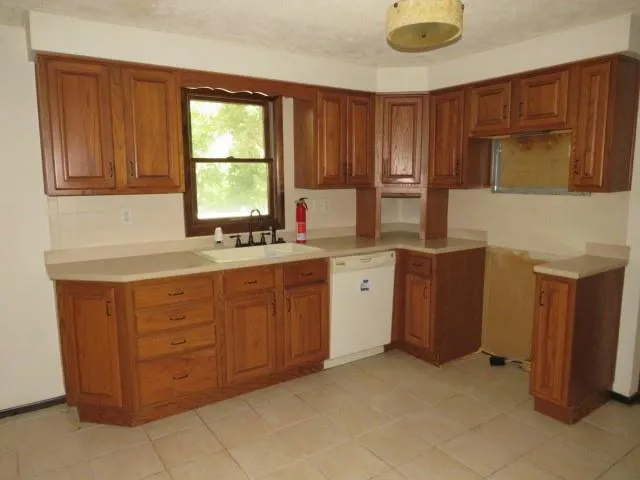 a kitchen with sink a window and cabinets