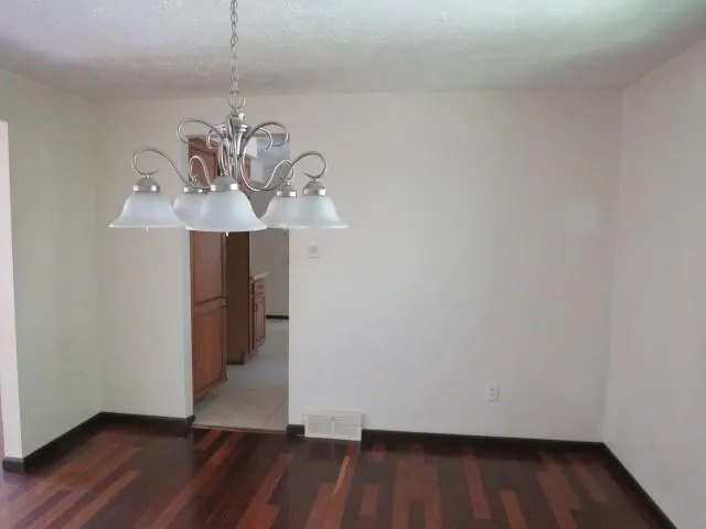a view of a room with wooden floor and ceiling fan
