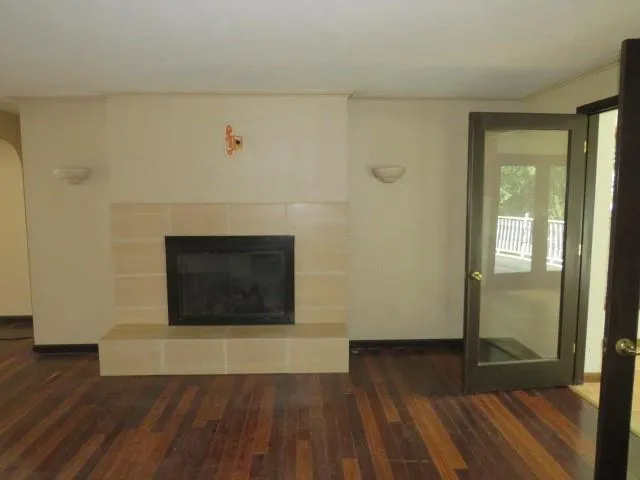 a living room with wooden floor and a fireplace