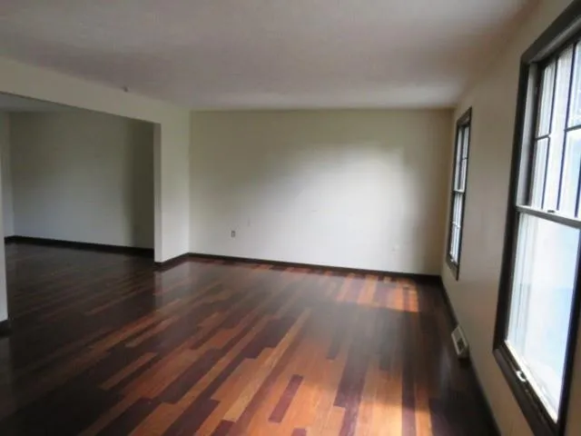 a view of a room with wooden floor and a window