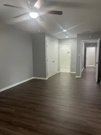 a view of an empty room with wooden floor