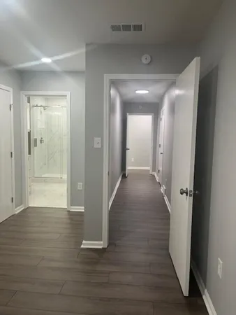 a view of a hallway with wooden floor
