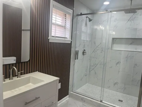 a bathroom with a sink a mirror and a shower