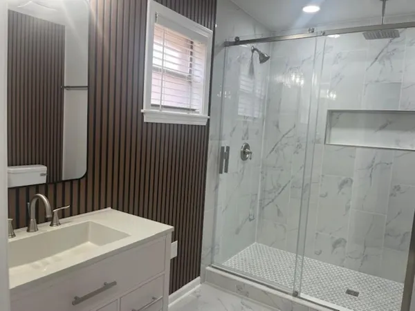 a bathroom with a sink a mirror and a shower