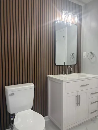 a bathroom with a toilet a sink and mirror