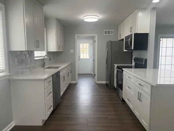 a kitchen with stainless steel appliances a sink dishwasher a refrigerator and a stove