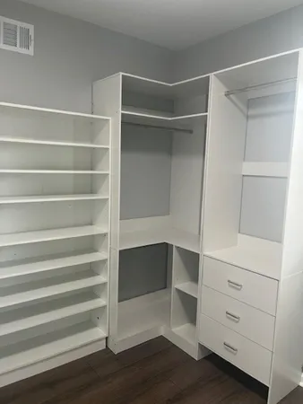a view of walk in closet with empty racks