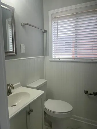 a bathroom with a sink a toilet and a window