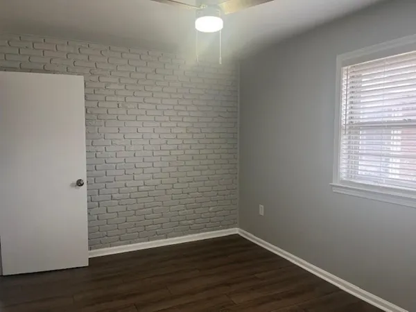 a view of a small space with wooden floor and a window