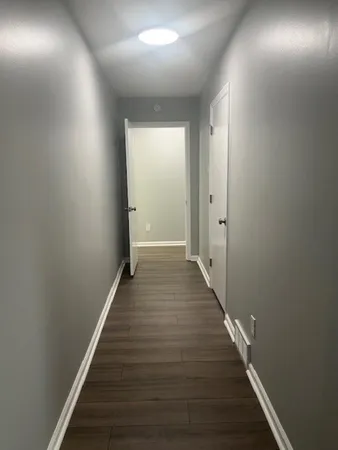 a view of a hallway with wooden floor