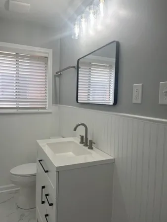a bathroom with a toilet a sink and a window
