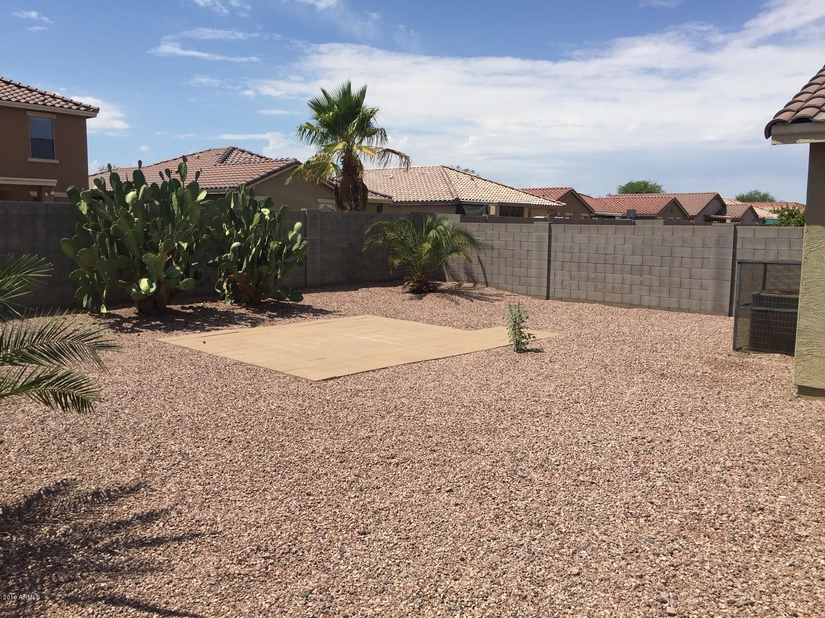 2515 West Romley Road Phoenix, AZ 85041 - Photo 17 of 20 a street view with large trees and buildings in the background