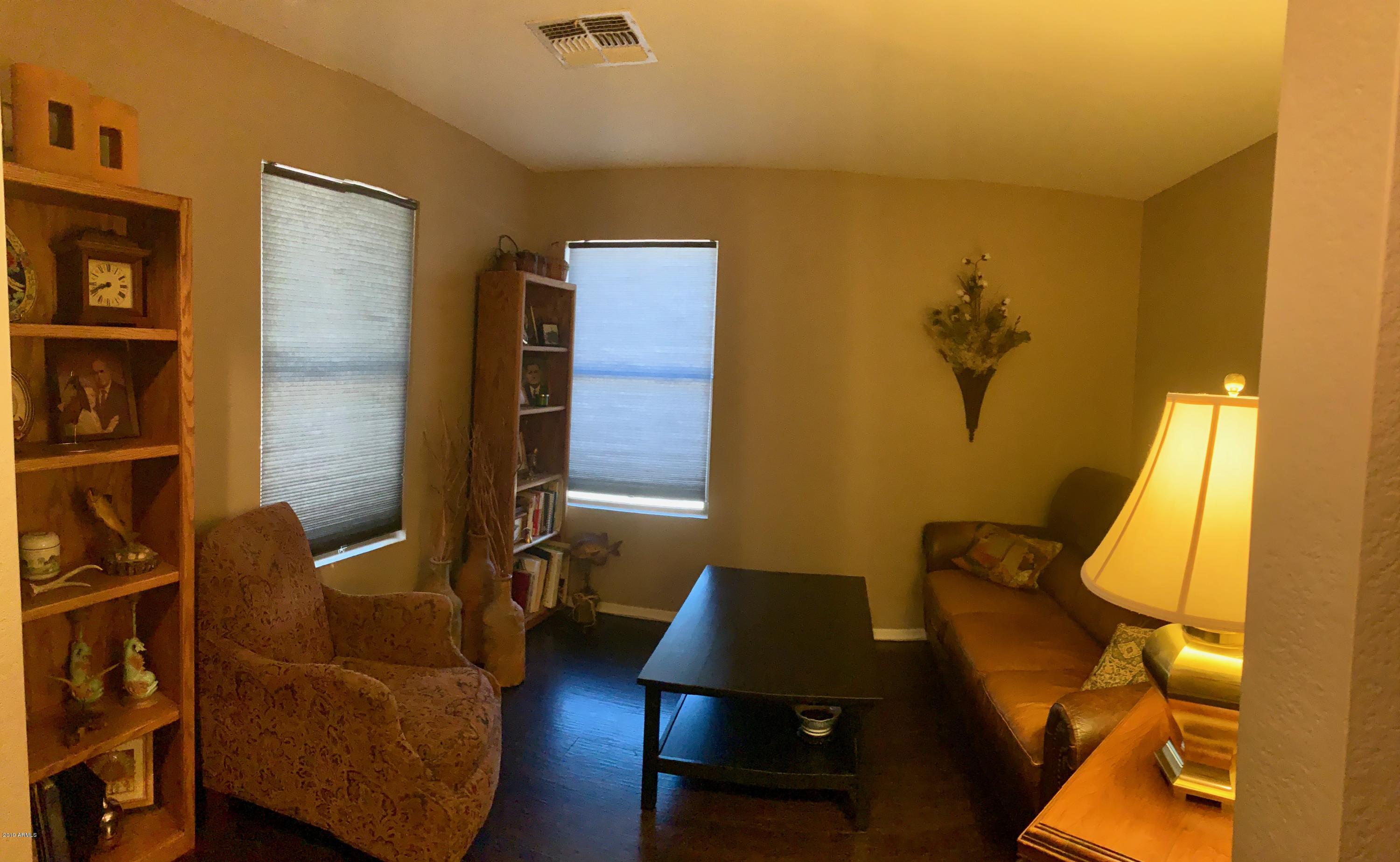2515 West Romley Road Phoenix, AZ 85041 - Photo 7 of 20 a living room with furniture and a lamp