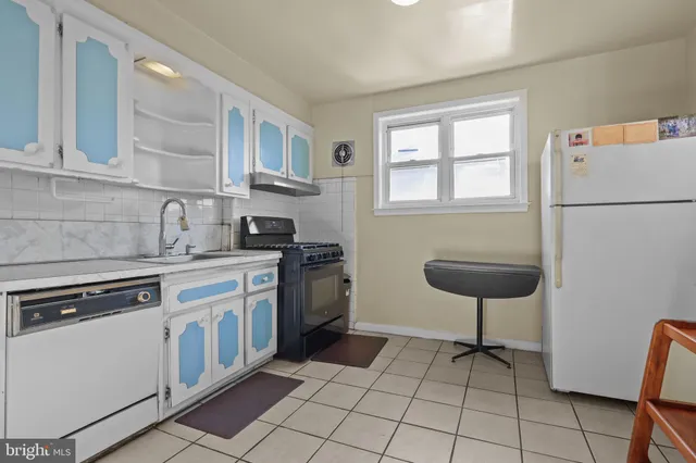 a kitchen with a stove a sink and a refrigerator