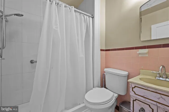 a white toilet sitting next to a shower curtain