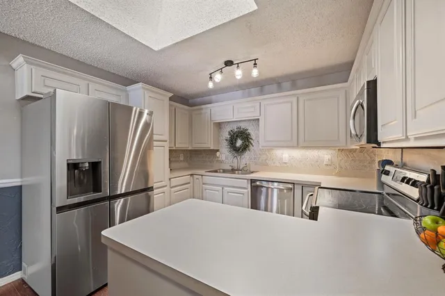a kitchen with stainless steel appliances a refrigerator sink and stove