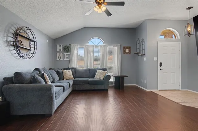 a living room with furniture and a wooden floor