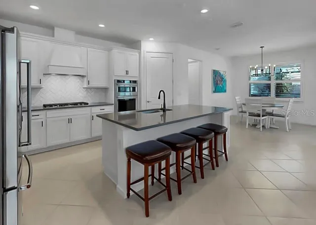 a kitchen with granite countertop sink table and chairs