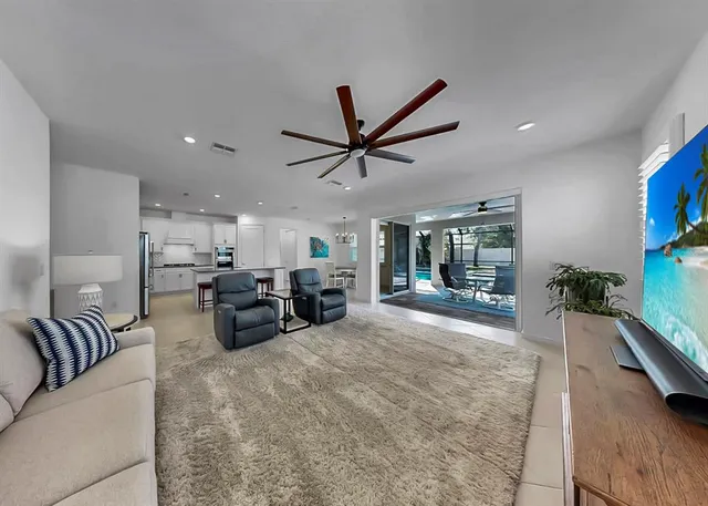 a living room with furniture large window and a flat screen tv