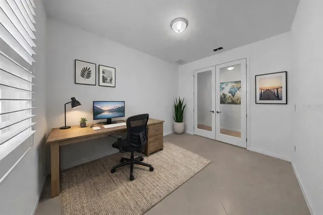 a view of a workspace with furniture and a window