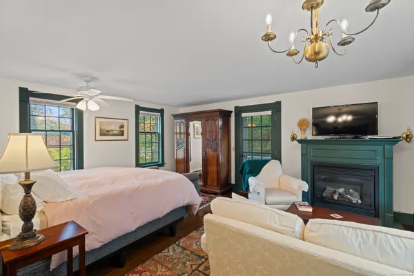 a bedroom with a bed wooden floor and flat screen tv