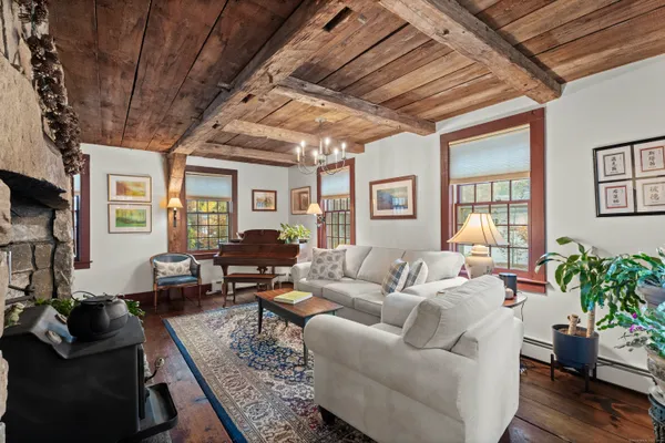 a living room with furniture potted plant wooden floor and a large window