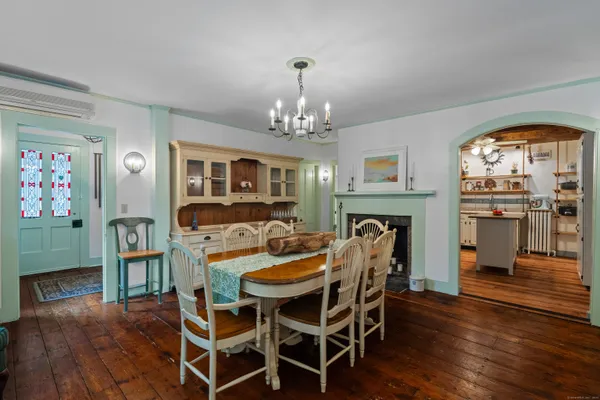 a dining room with furniture a chandelier and wooden floor