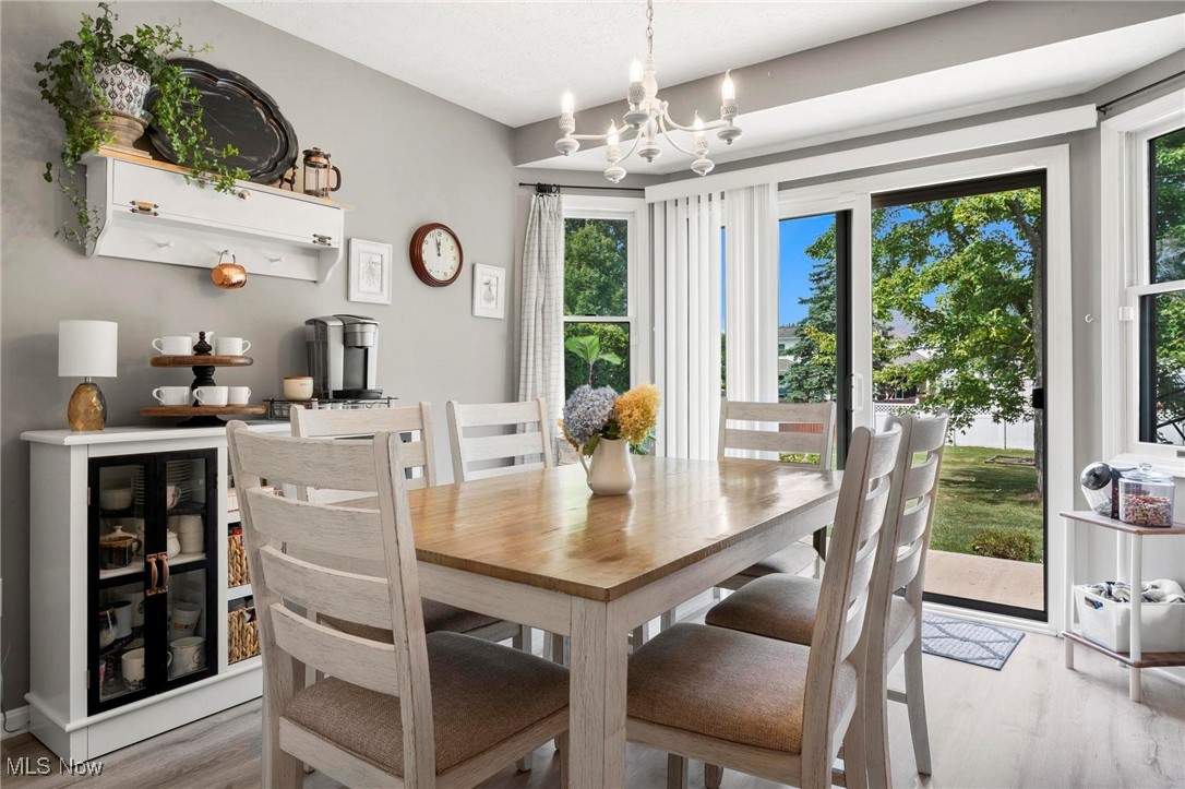 Dining area with light hardwood / wood-style floors and a chandelier