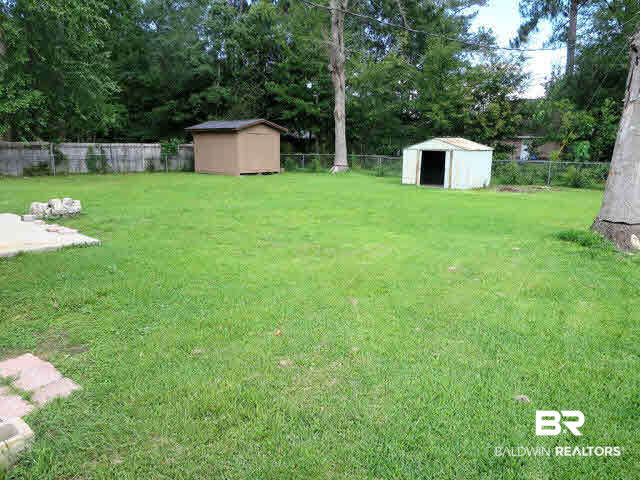 204 West Sycamore Avenue Foley, AL 36535 - Photo 10 of 11 Large fenced in back yard with two outbuildings. Perfect for enjoying the sun outside!
