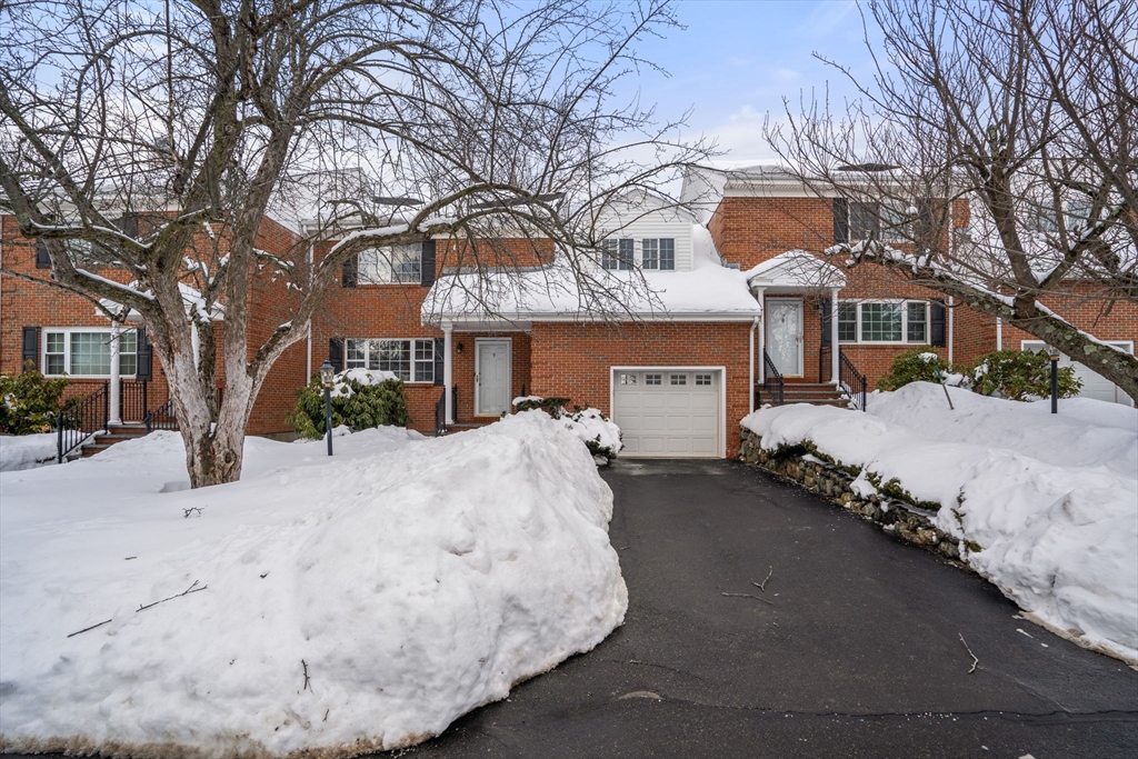 a front view of a house with a yard covered in snow