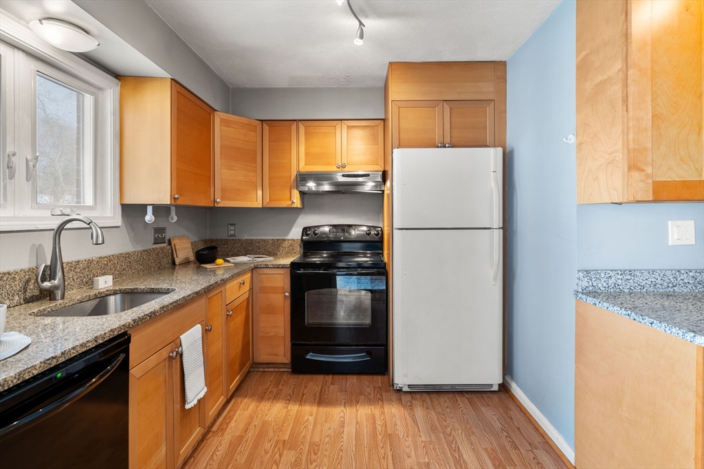9 April Lane, Unit 9 Lexington, MA 02421 - Photo 16 of 38 a kitchen with a refrigerator a sink and wooden floor
