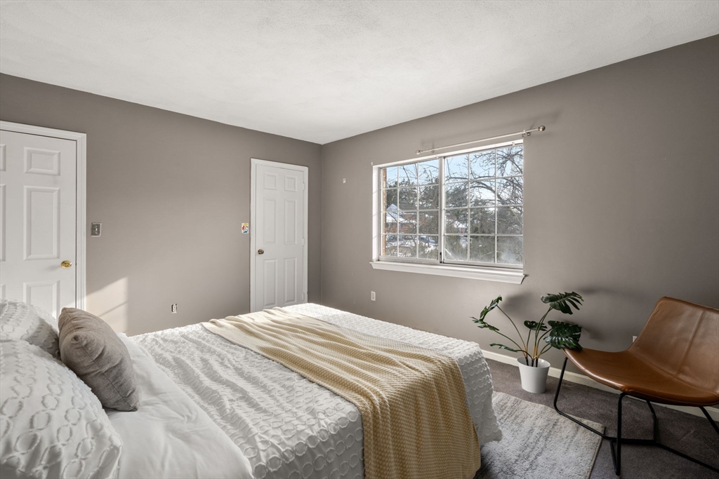 9 April Lane, Unit 9 Lexington, MA 02421 - Photo 27 of 38 a bedroom with a bed and a chair