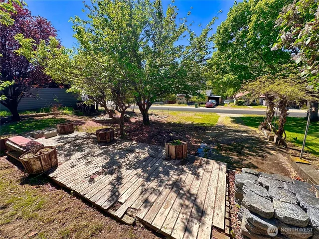 a view of a swimming pool with a patio and a yard