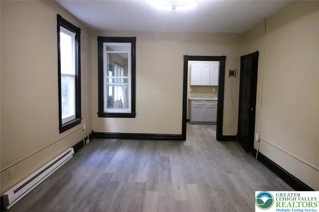 an empty room with windows and closet