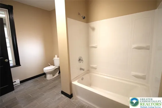 a bathroom with a bathtub and a toilet