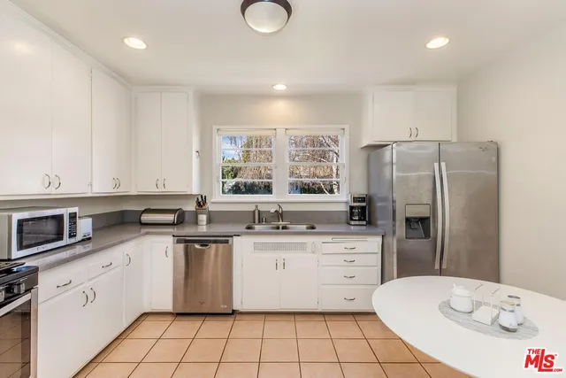 a kitchen with stainless steel appliances a sink stove refrigerator and cabinets